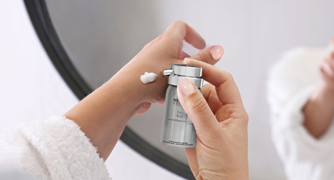 Person trägt mit einem NEOVITA Serum-Dispenser eine pflegende Creme auf die Hand auf. Symbolisch für die gezielte Versorgung der tiefen Hautschichten mit hochwirksamen Seren.
